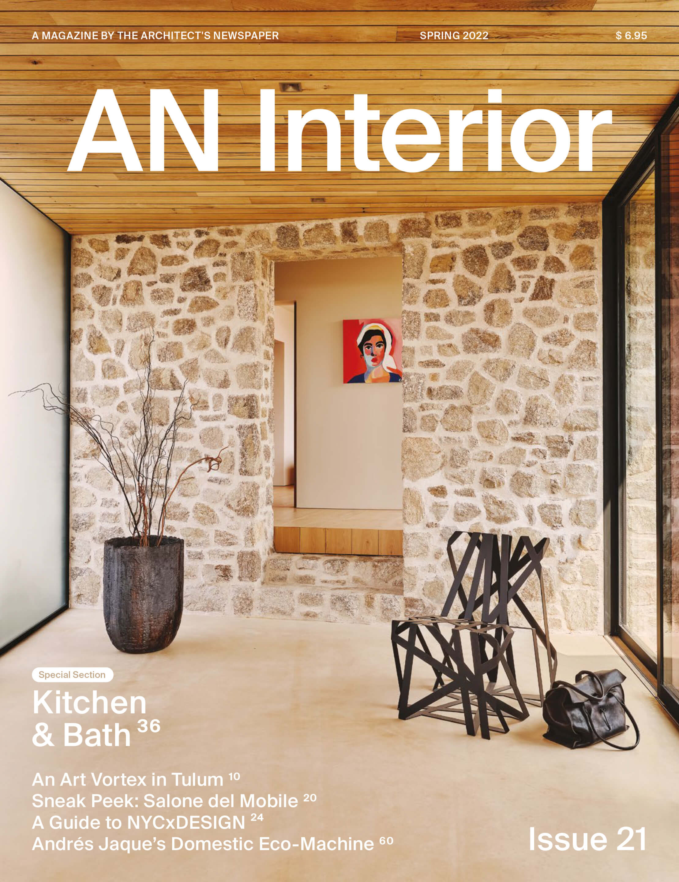 Cover of AN Interior magazine with chair, stone wall, and wood ceiling