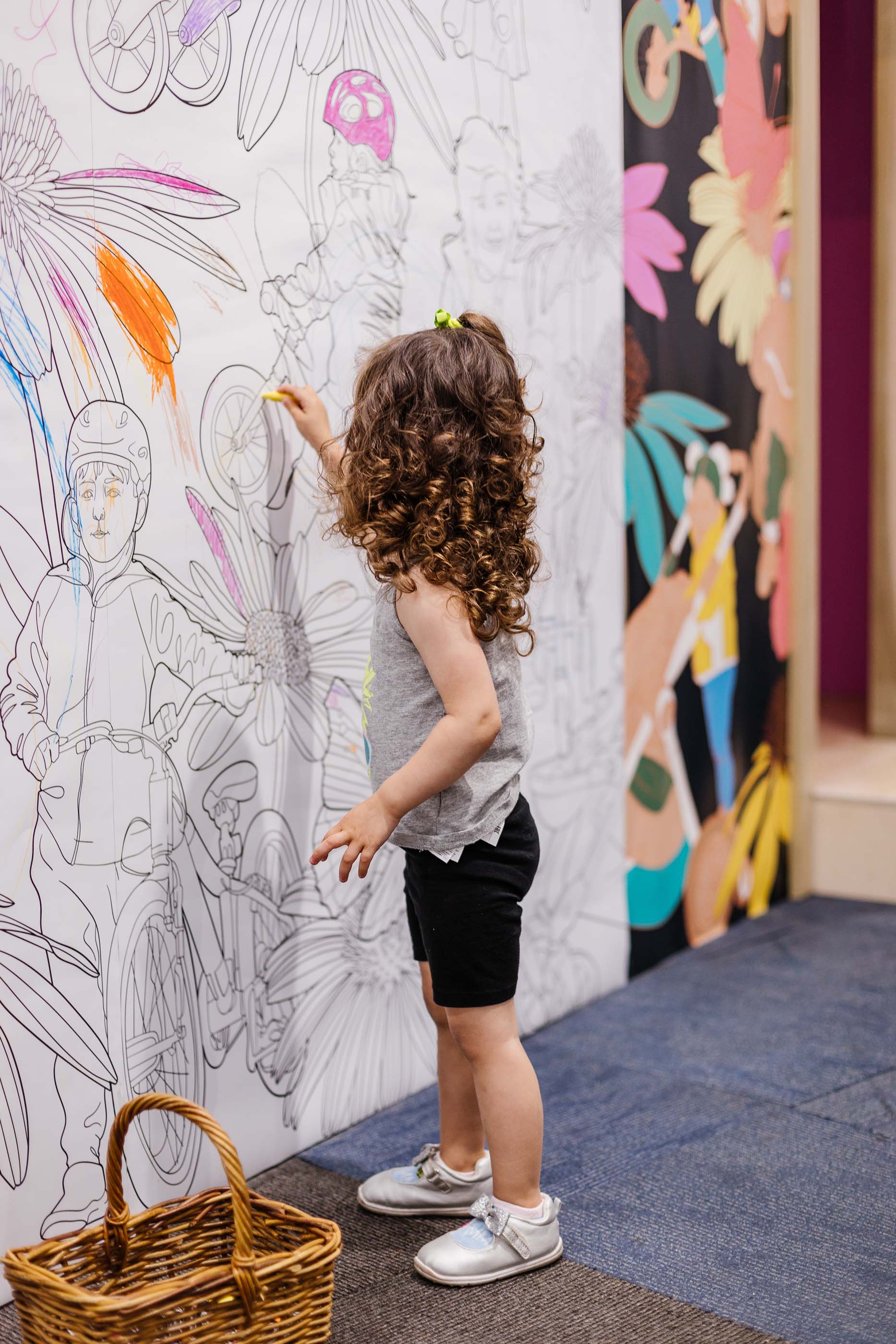 child colors a blank mural