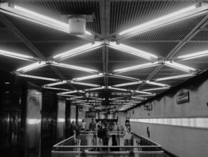 photograph depicting the interior of a New York City subway with crisscrossing light array