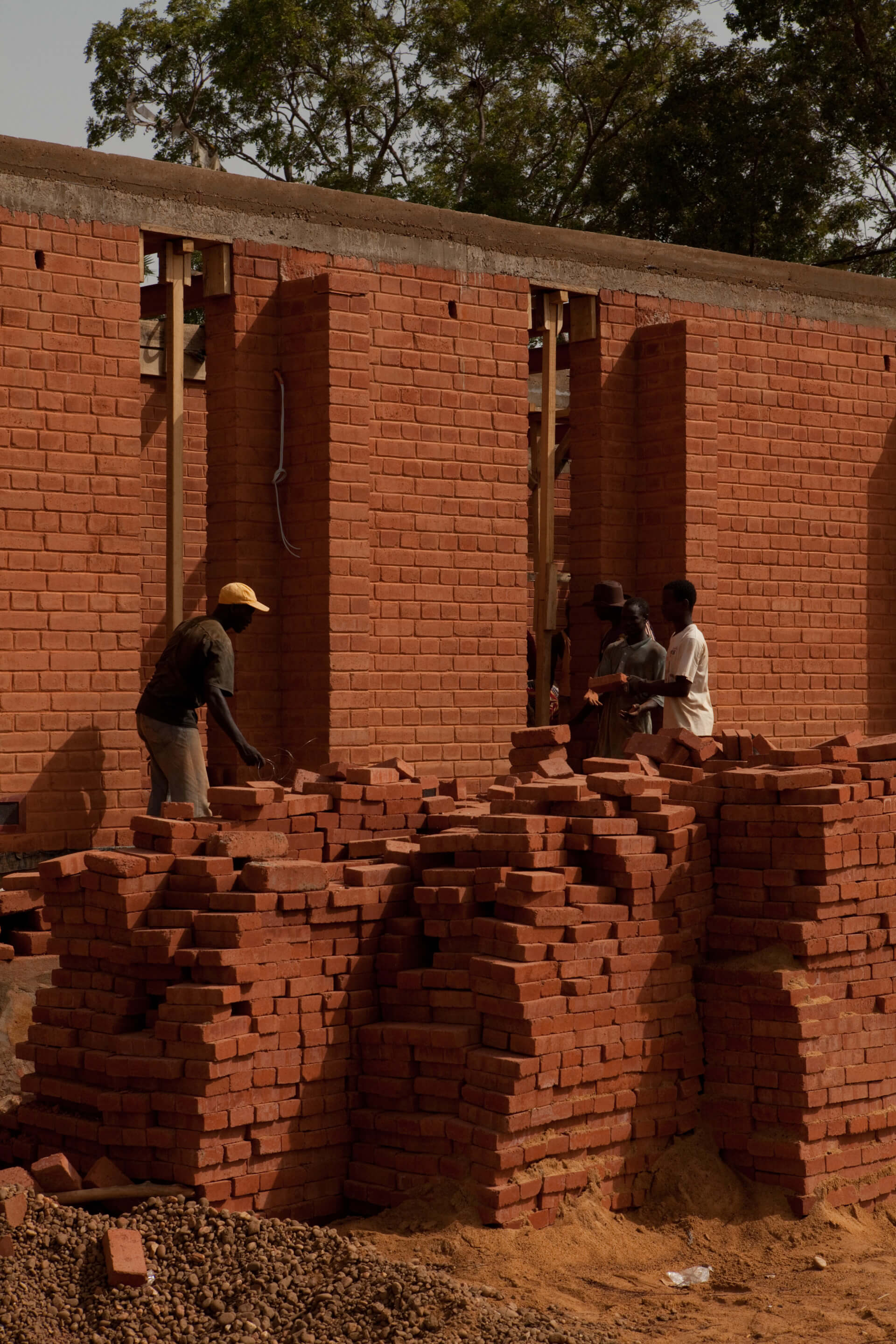 men building an earthen brick structure 