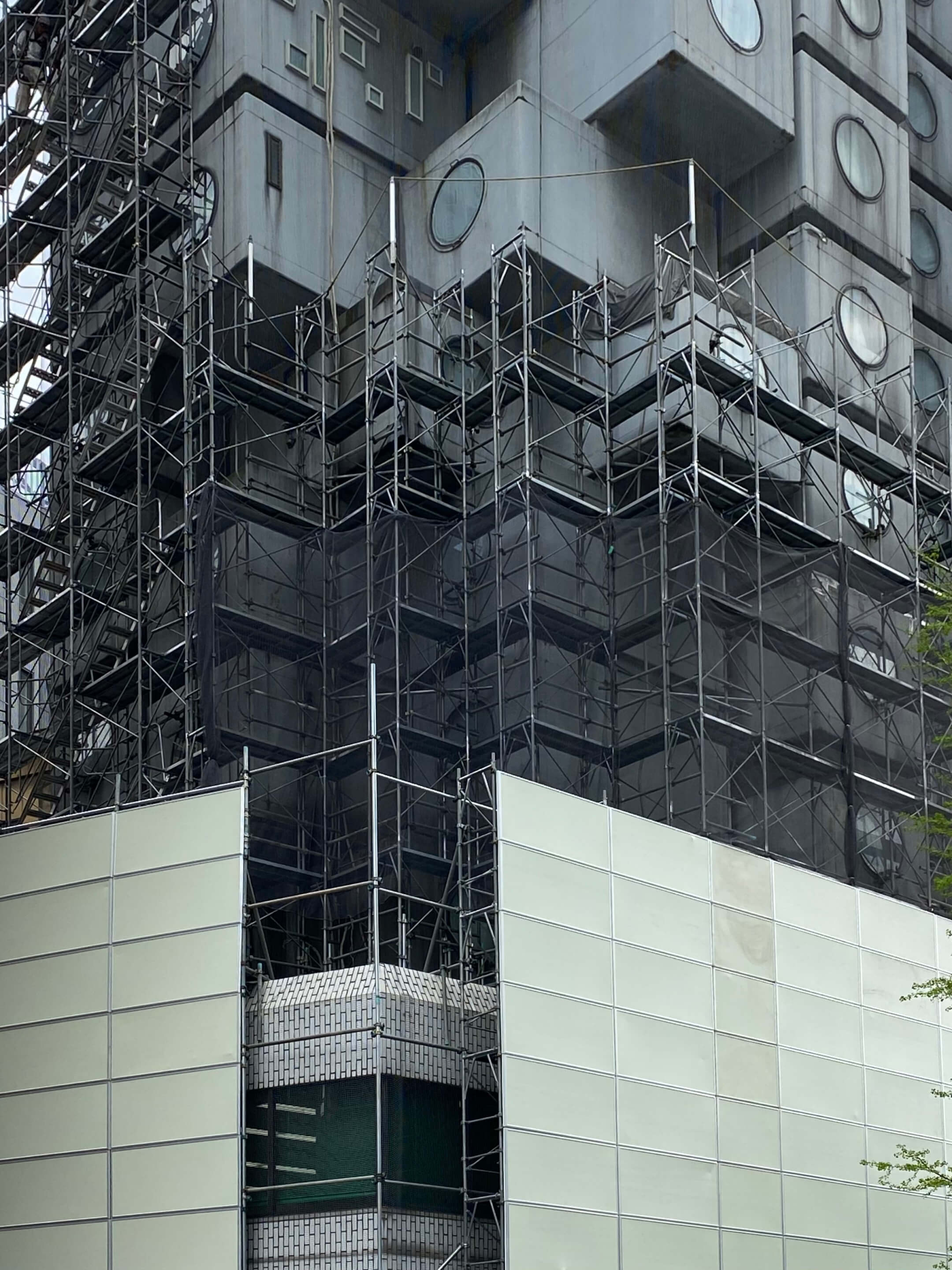 the nakagin capsule tower wrapped in scaffolding
