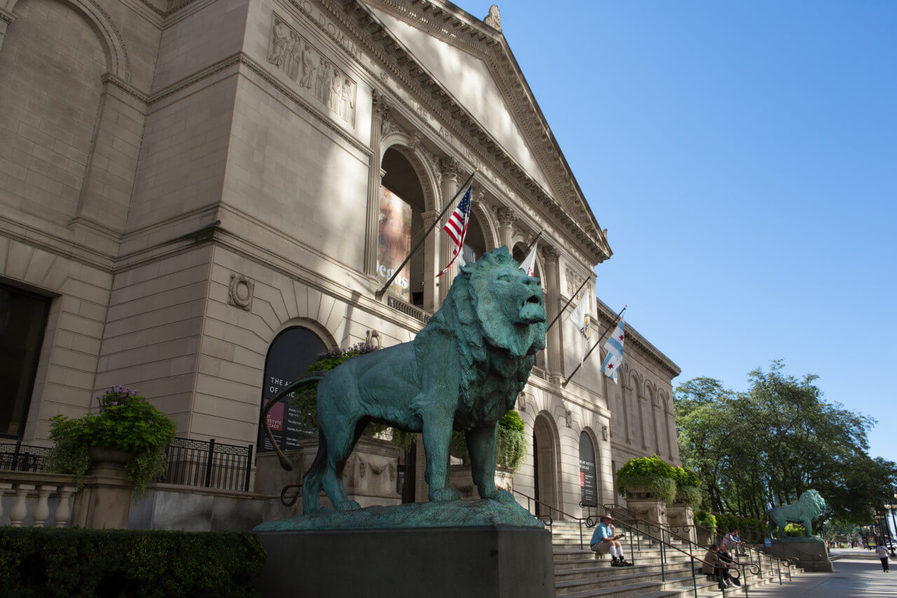 bronze lion statue on plinth outside building