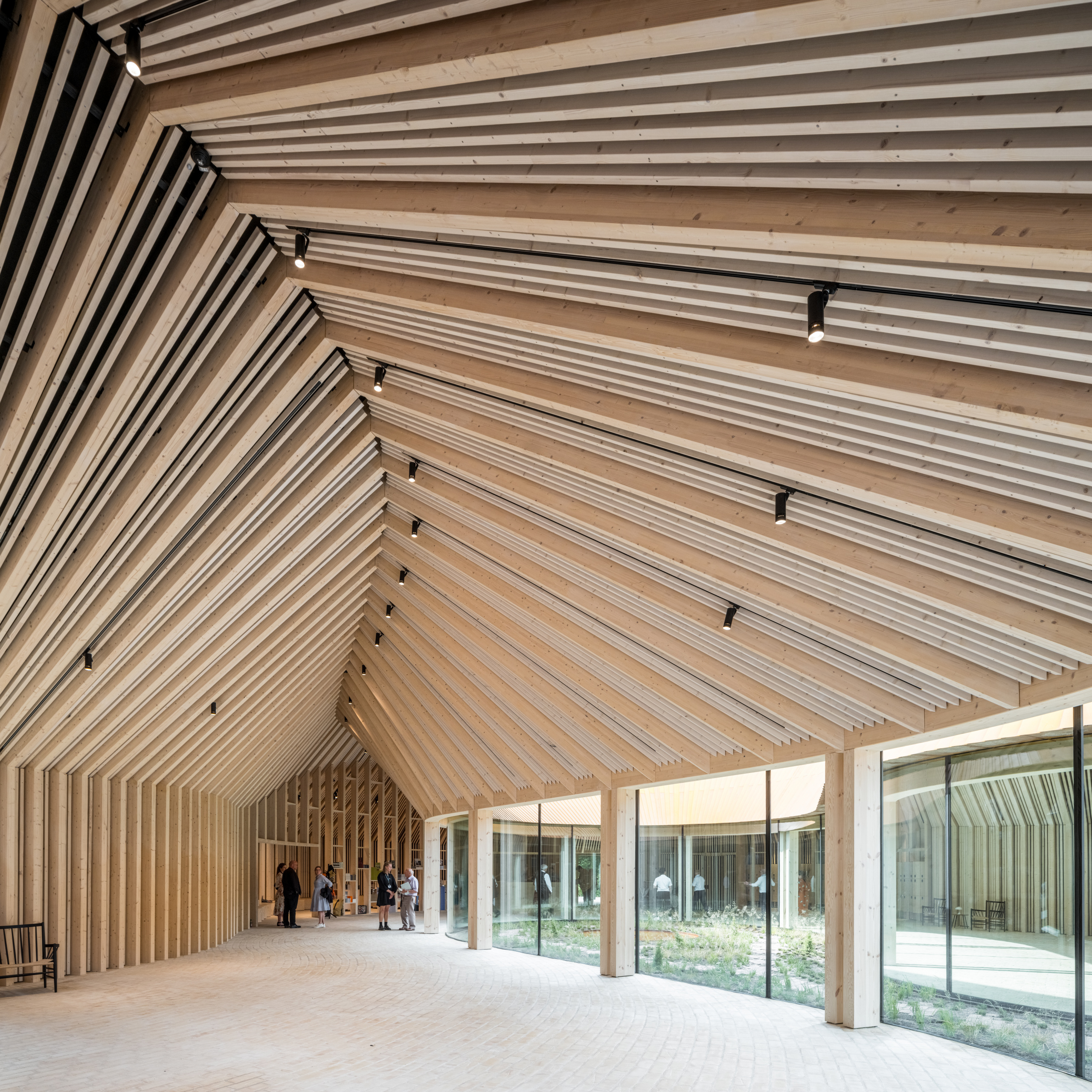 a large open museum space with a slender wooden ceiling 
