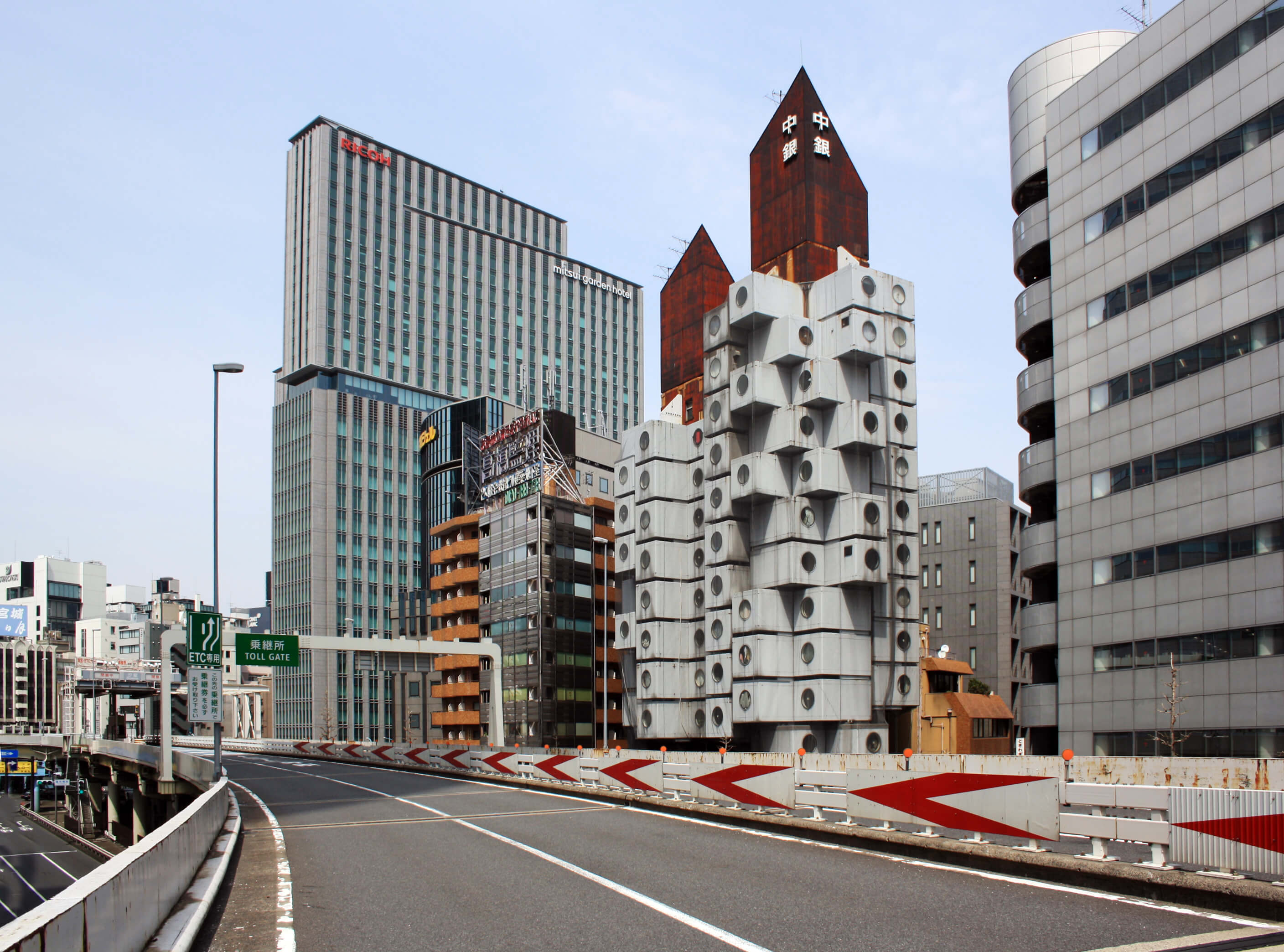 view of the nakagin capsule tower from a tokyo freeway