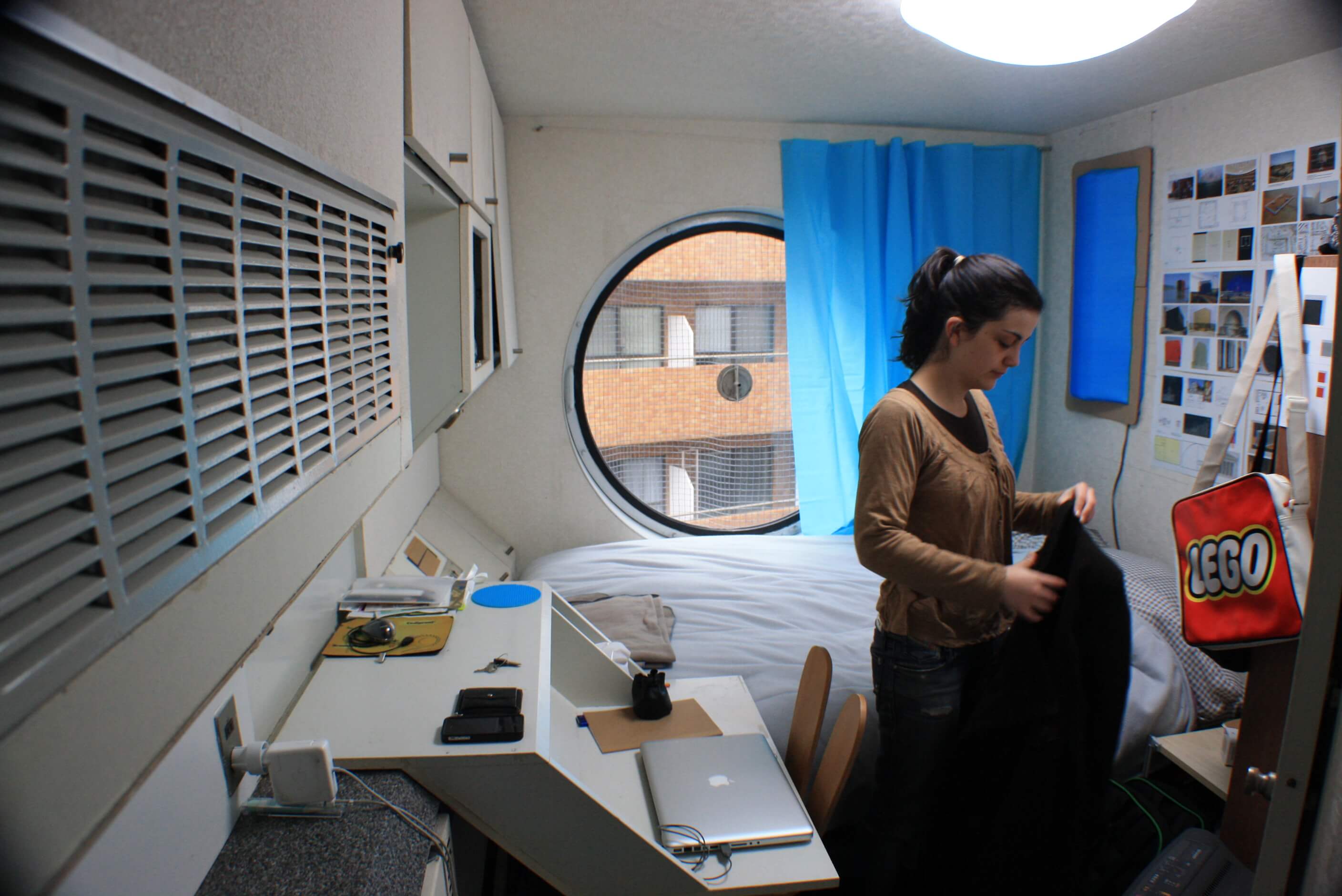 a woman inside a compact capsule apartment in tokyo