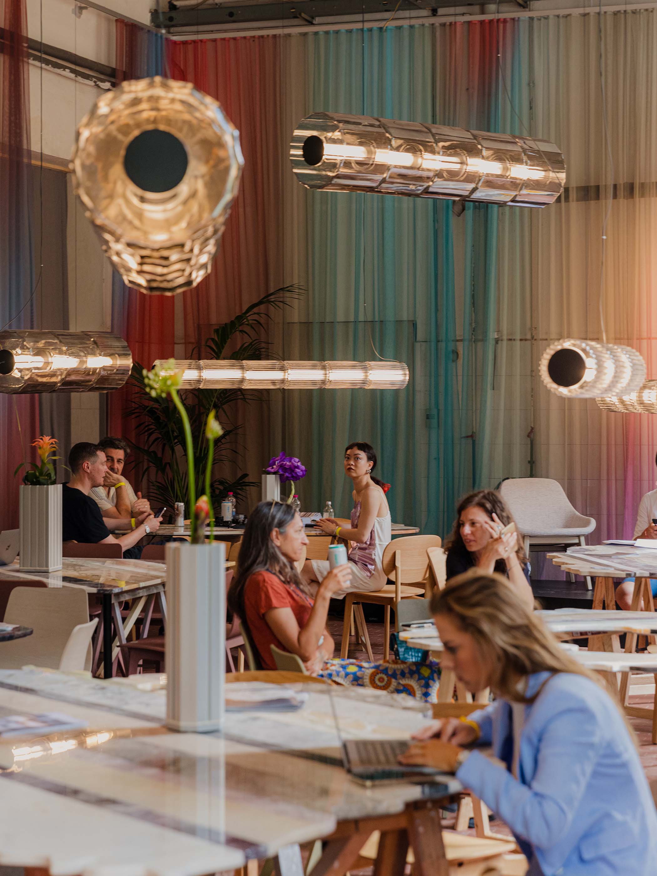 cylindrical light fixtures hang from ceiling in cafe space