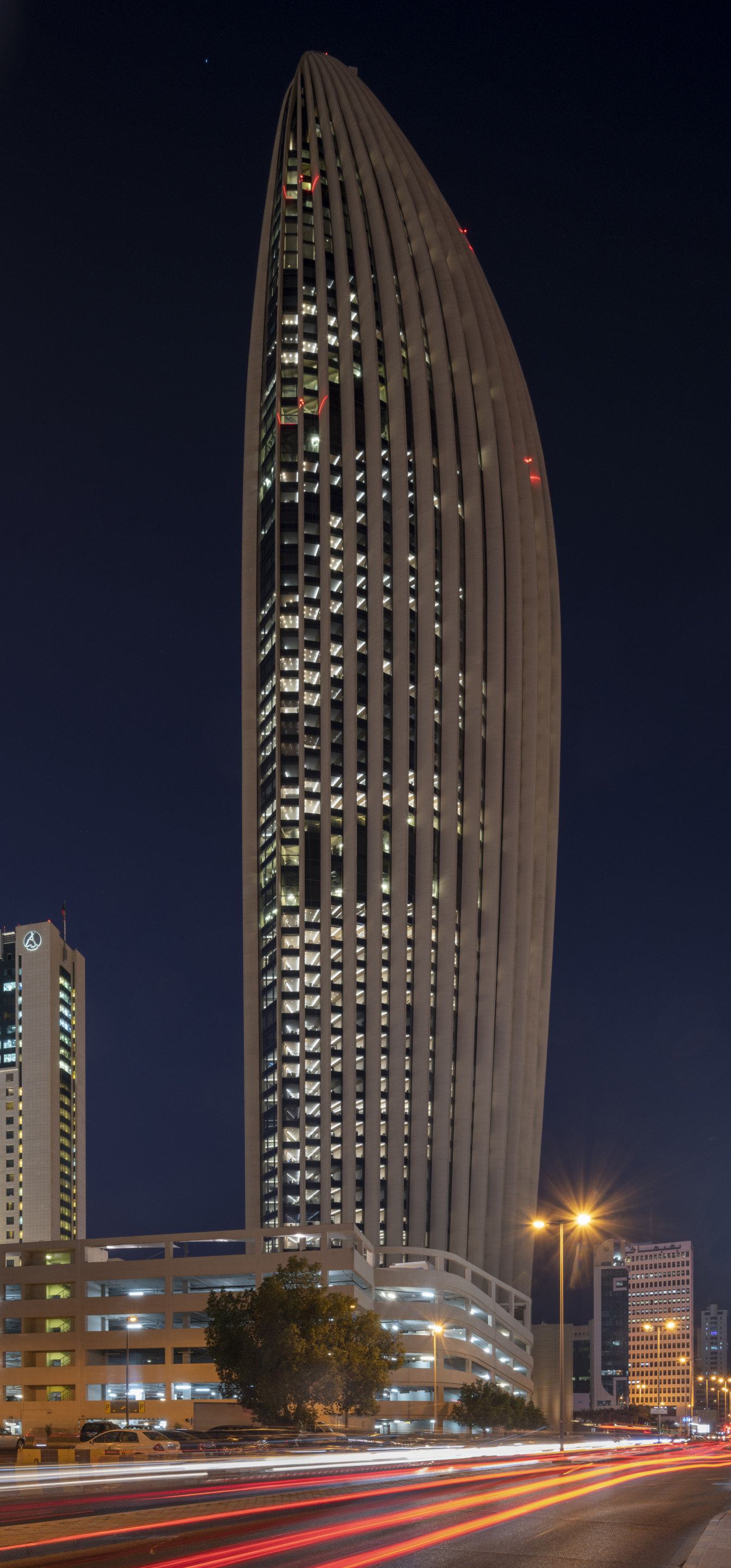 a rounded skyscraper pictured at night