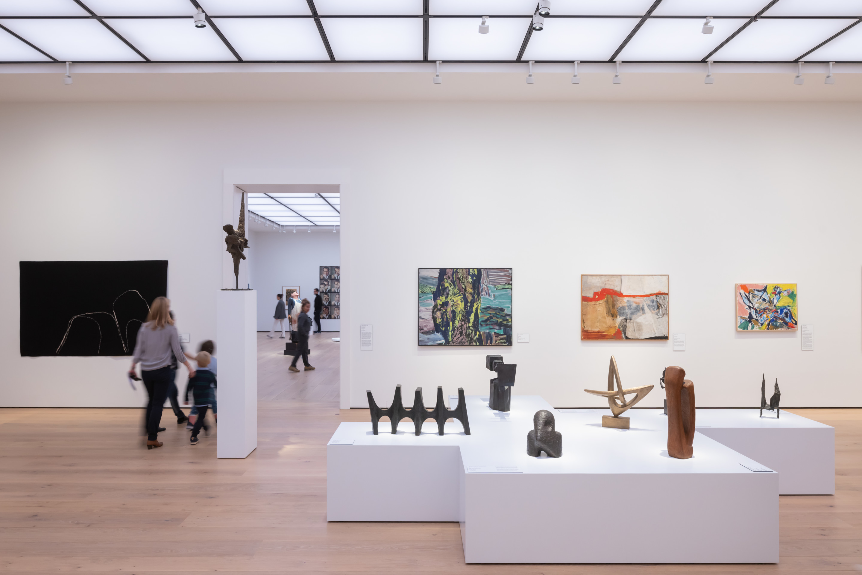 a stark white museum gallery with objects on display