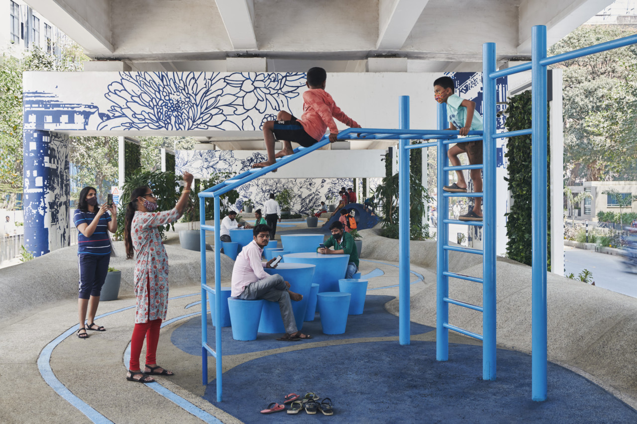 children frolic on a bright blue play structure