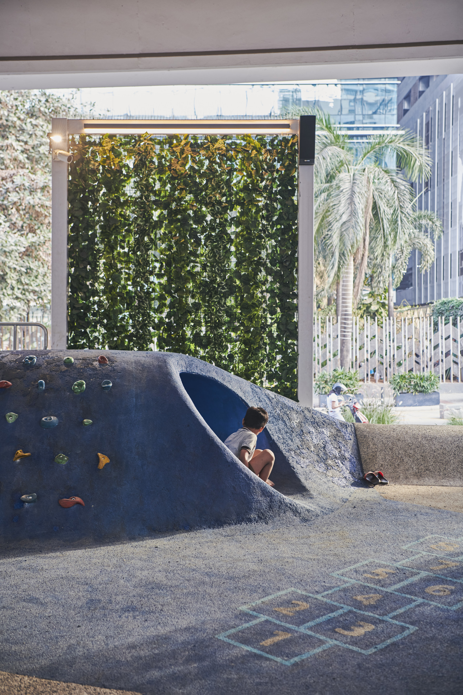 a child emerges from a hill-shaped play structure