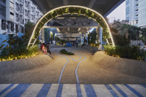 a plant-covered archway beneath an elevated highway