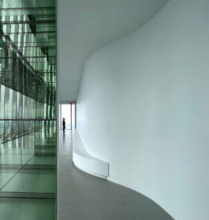a long hallway with a curving form and glass