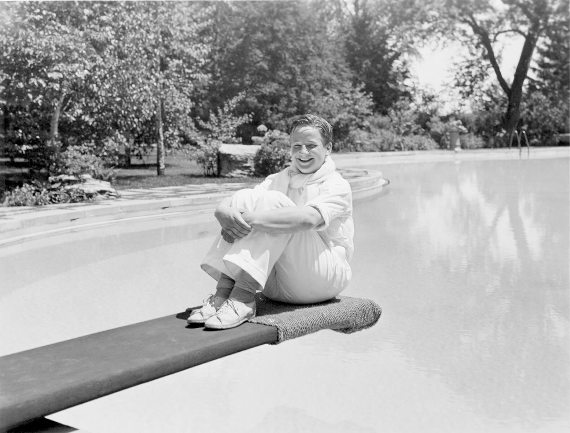 a ford family member sits on a diving board in a historic photograph