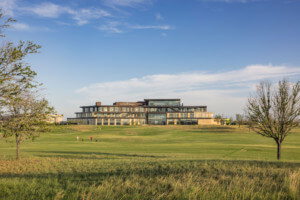 view of a large tiered building from across a golf course