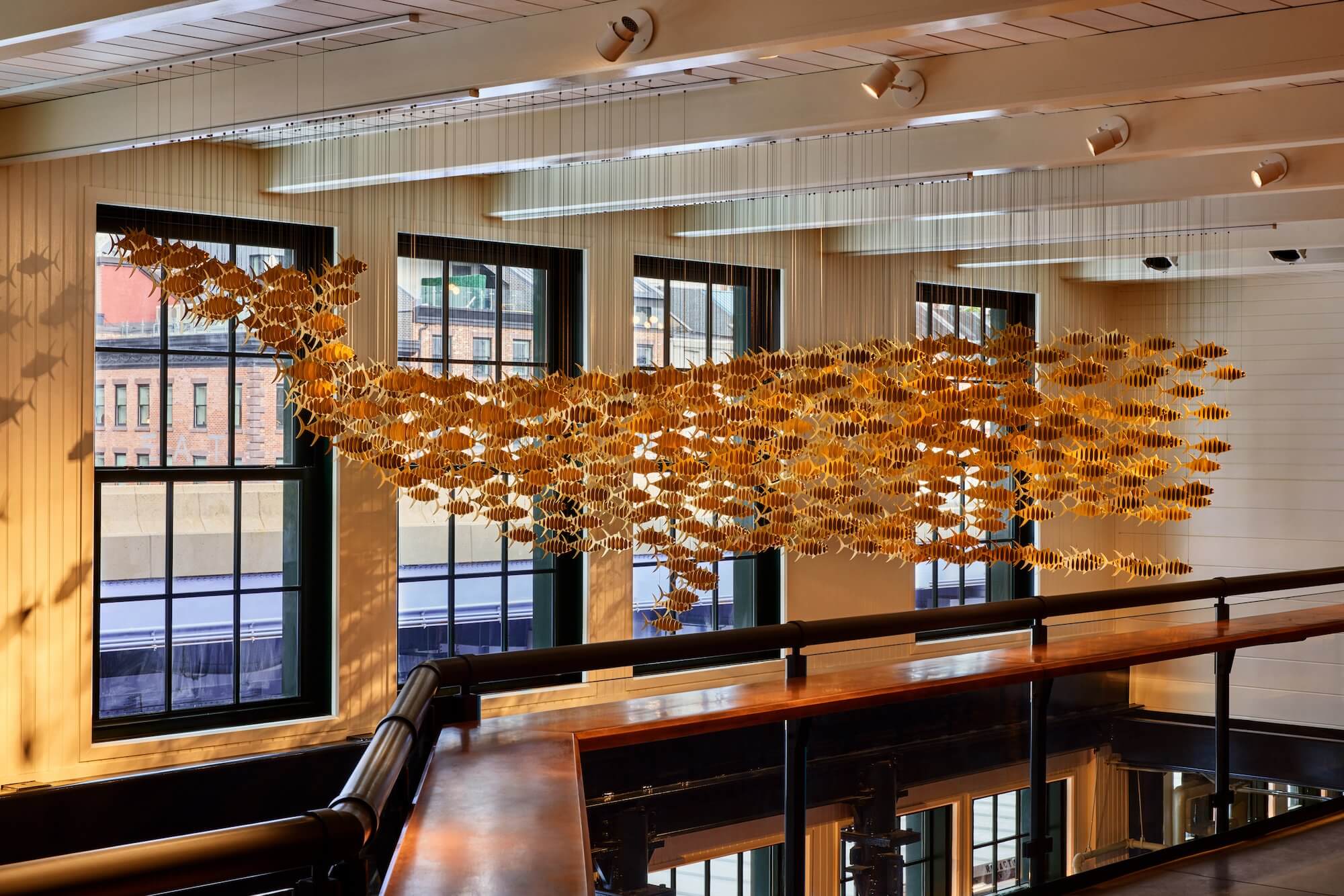 a hanging art installation featuring fish in a marketplace