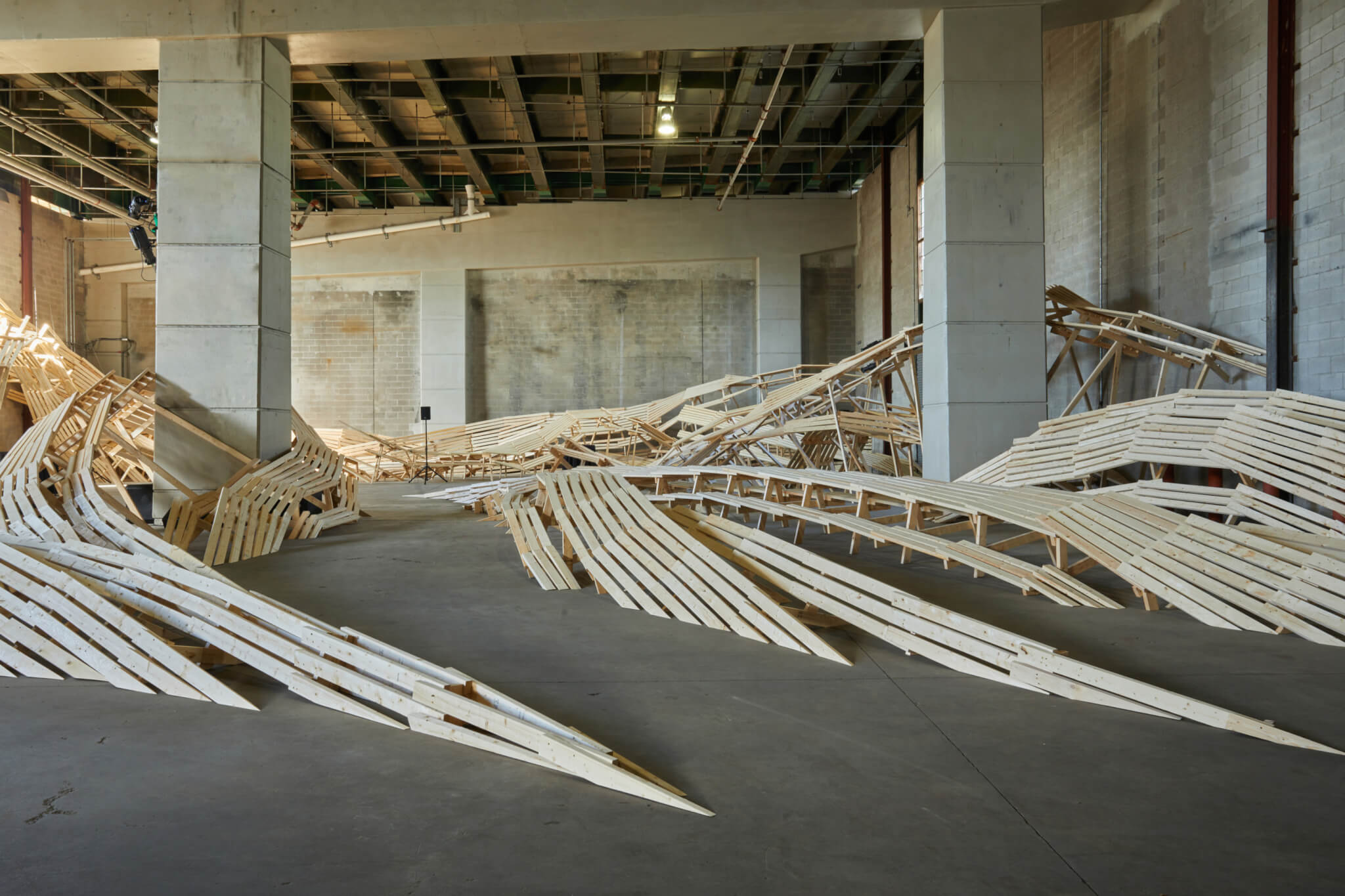 a large-scale installation with undulating wooden forms