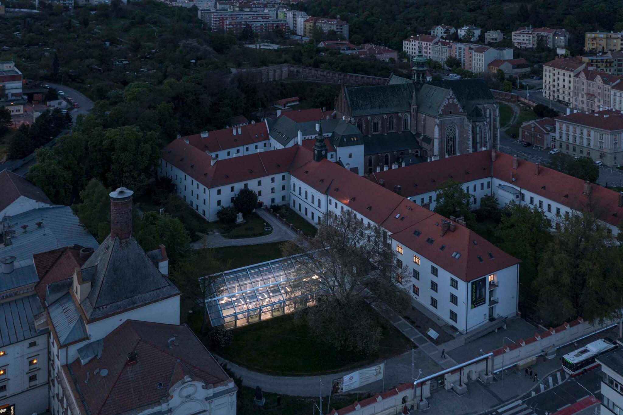 aerial view of greenhouse lit up next to historic abbey