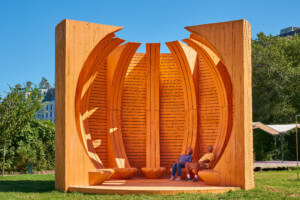 Couple sits within large cedar structure