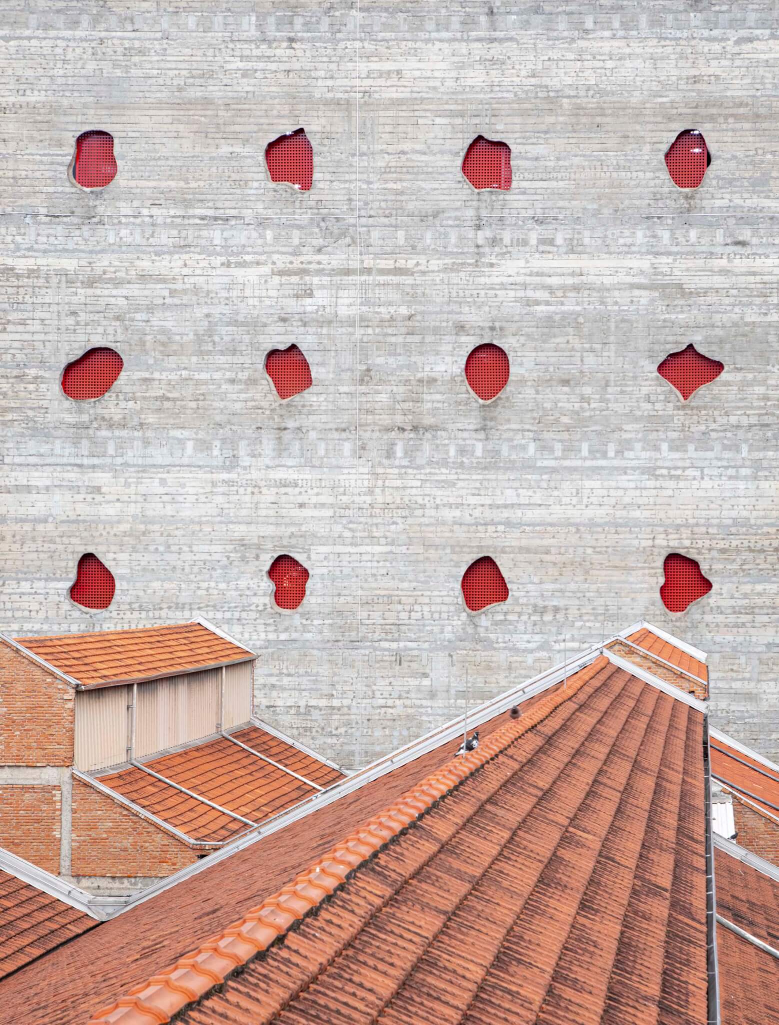 view of concrete wall punctured with red holes