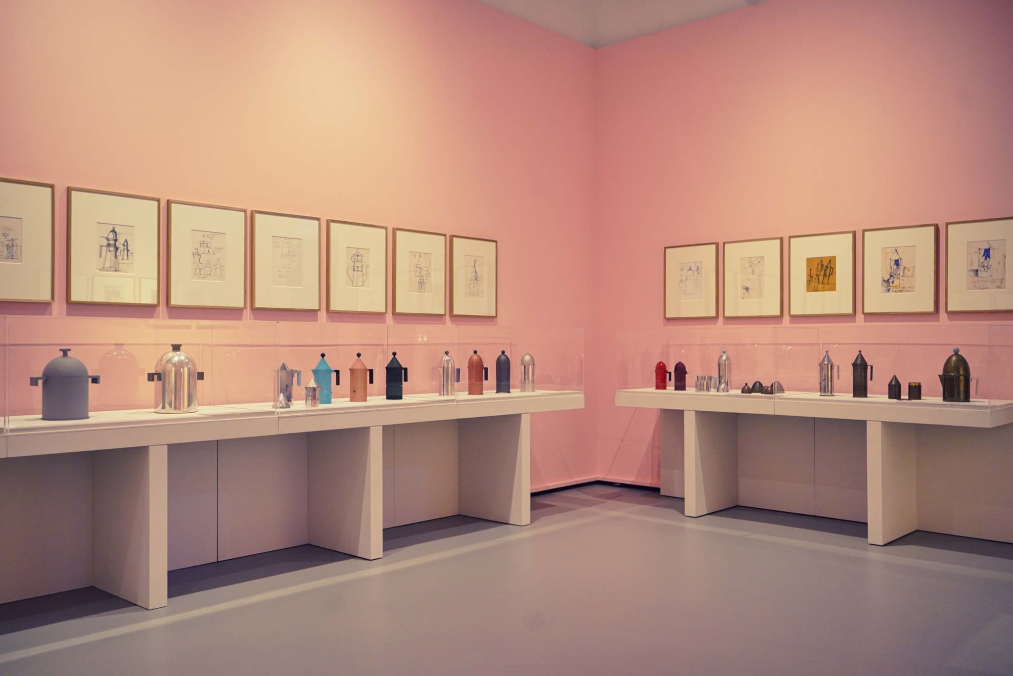 sketches line pink walls and coffee pot objects line shelves