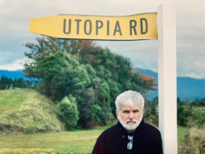 photo of Mike Davis below a sign that says Utopia Rd