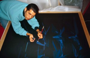 antonio de campos with drawing utensil leaning over a drawing
