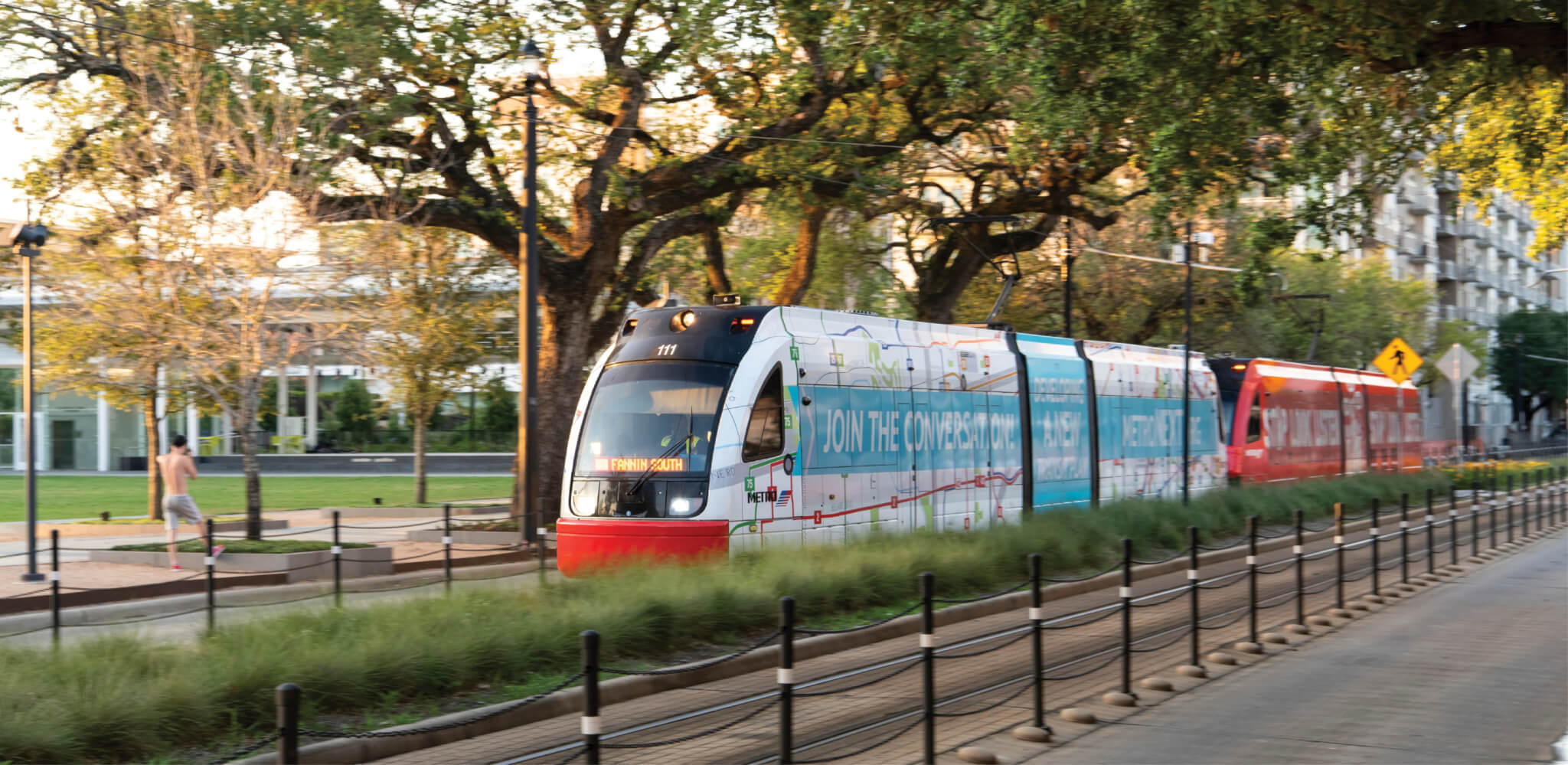 a street tram moves through a park-like landscape