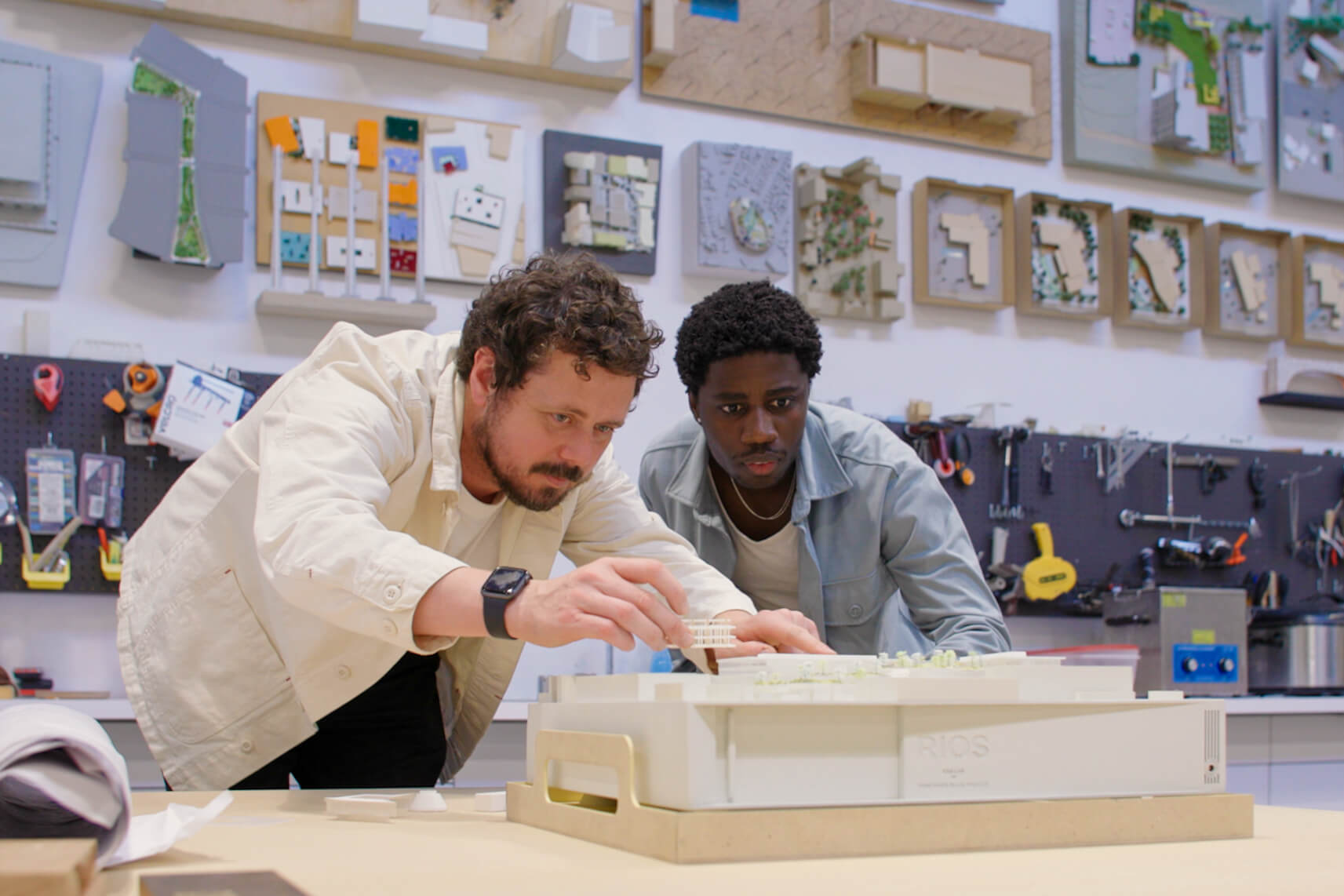 two men look at an architectural model