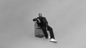 black and white photograph of virgil abloh leaning against crates
