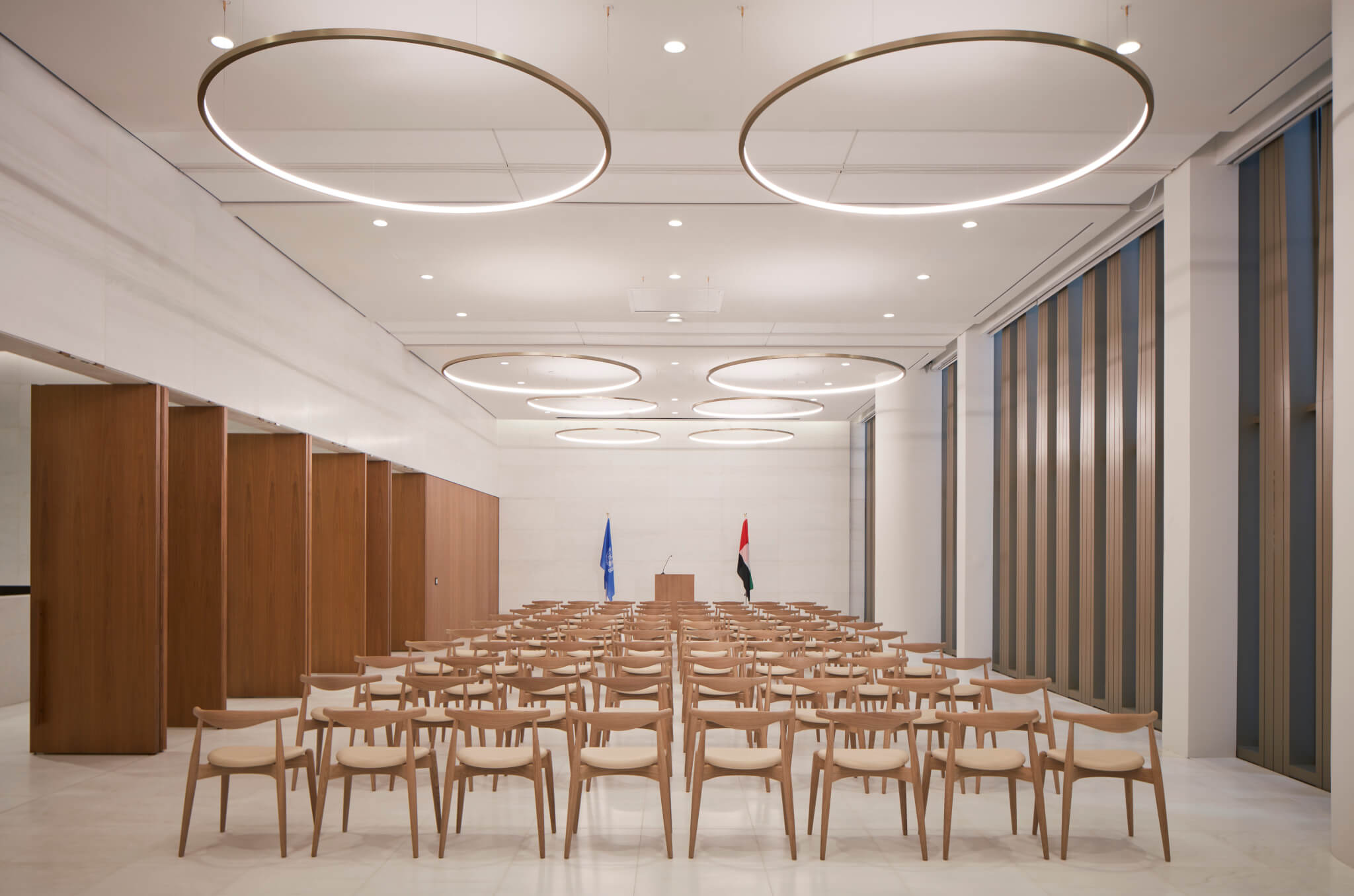 circular light fixtures with chairs lined up in rows