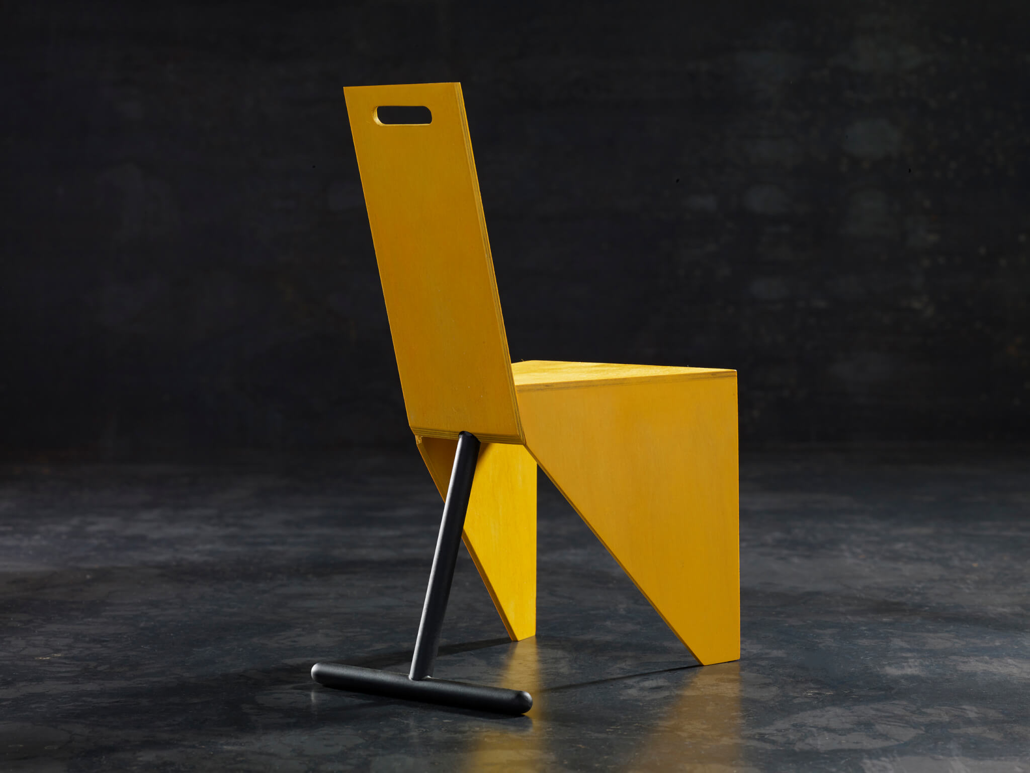 yellow chair in black backdrop