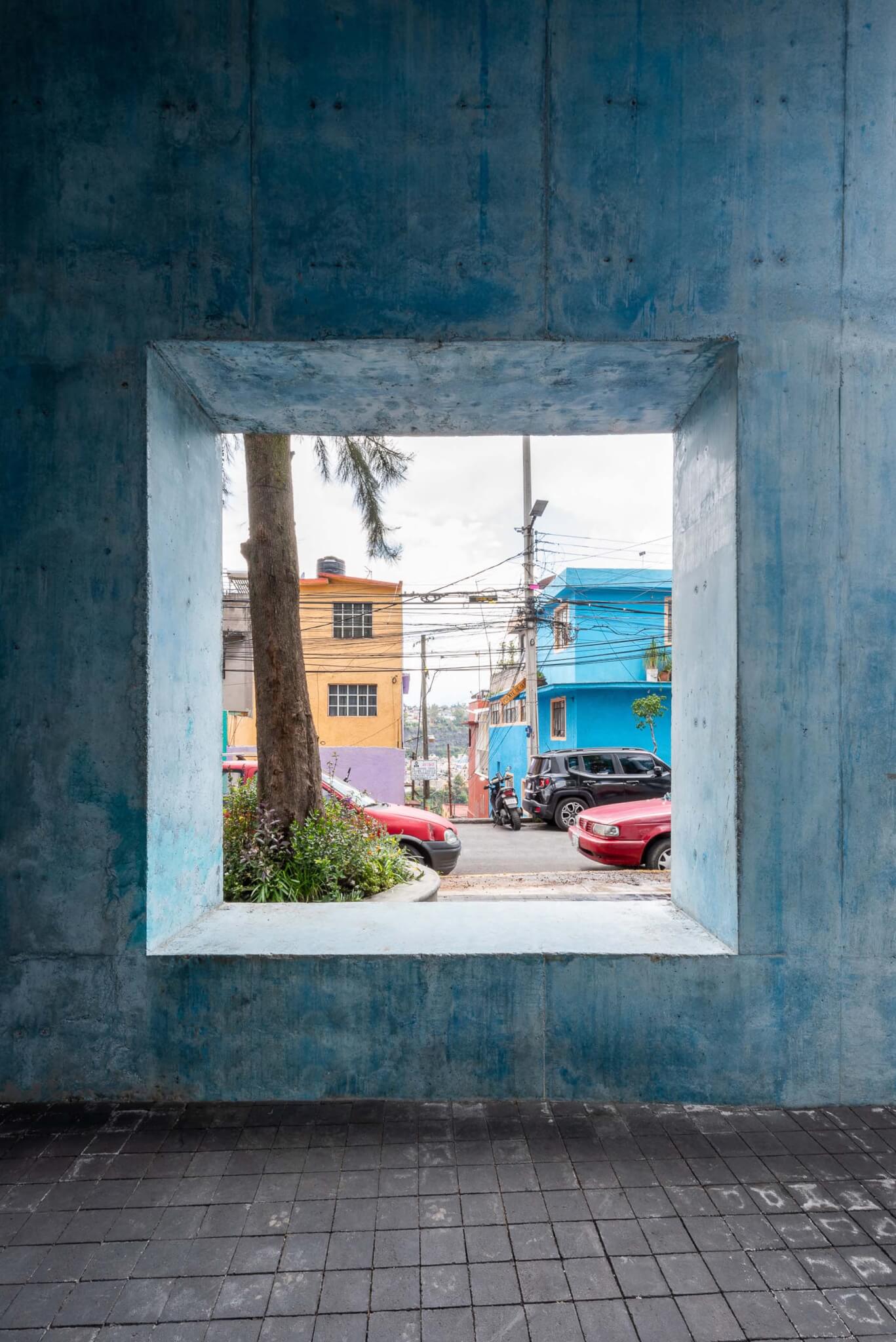 square window with blue concrete interior