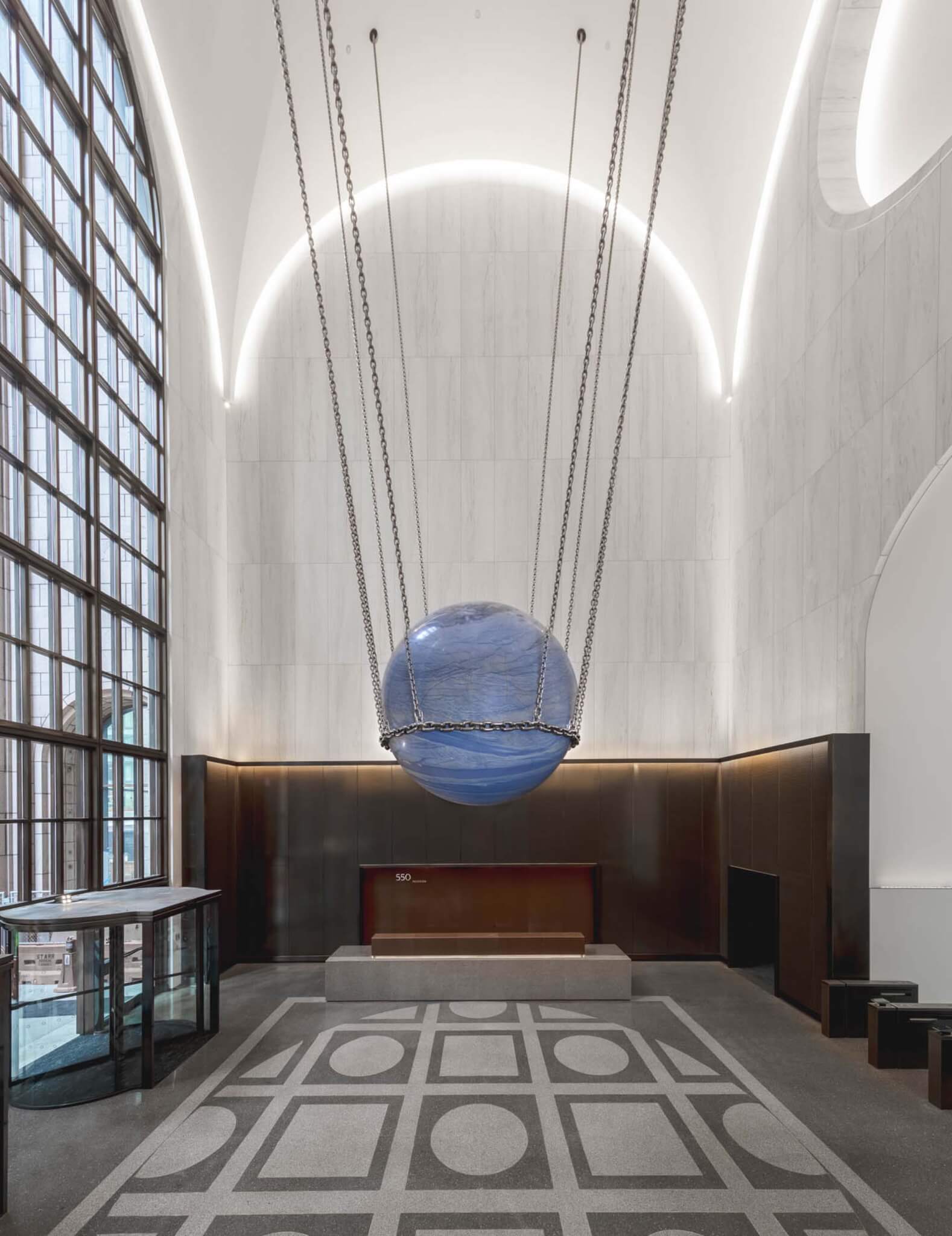 blue orb sculpture hanging from ceiling in lobby