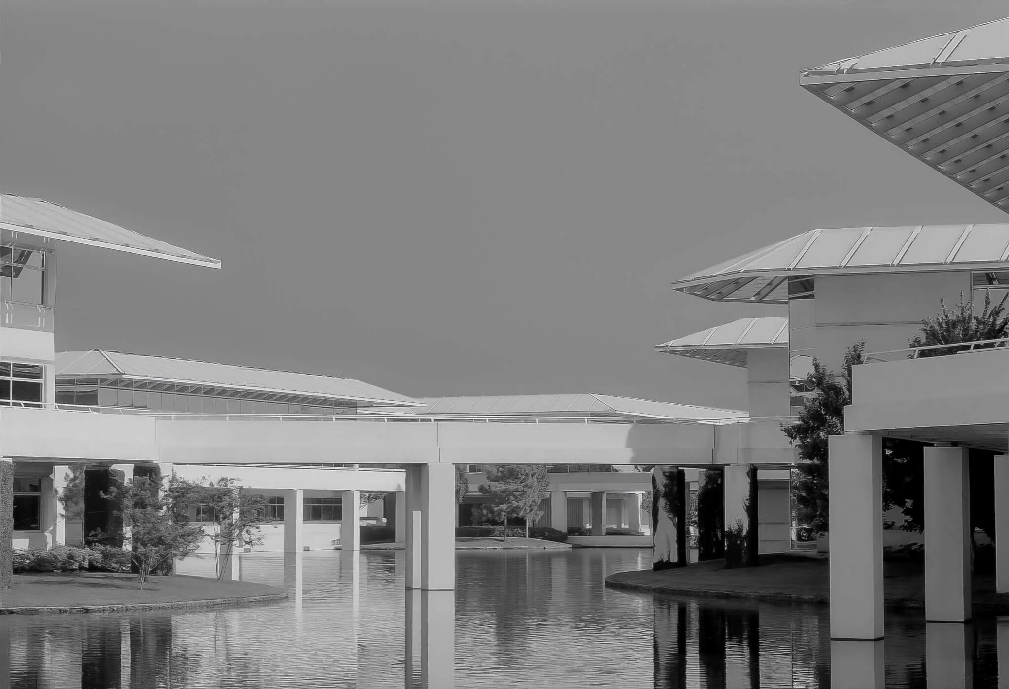 black and white photo of building spanning over waterway