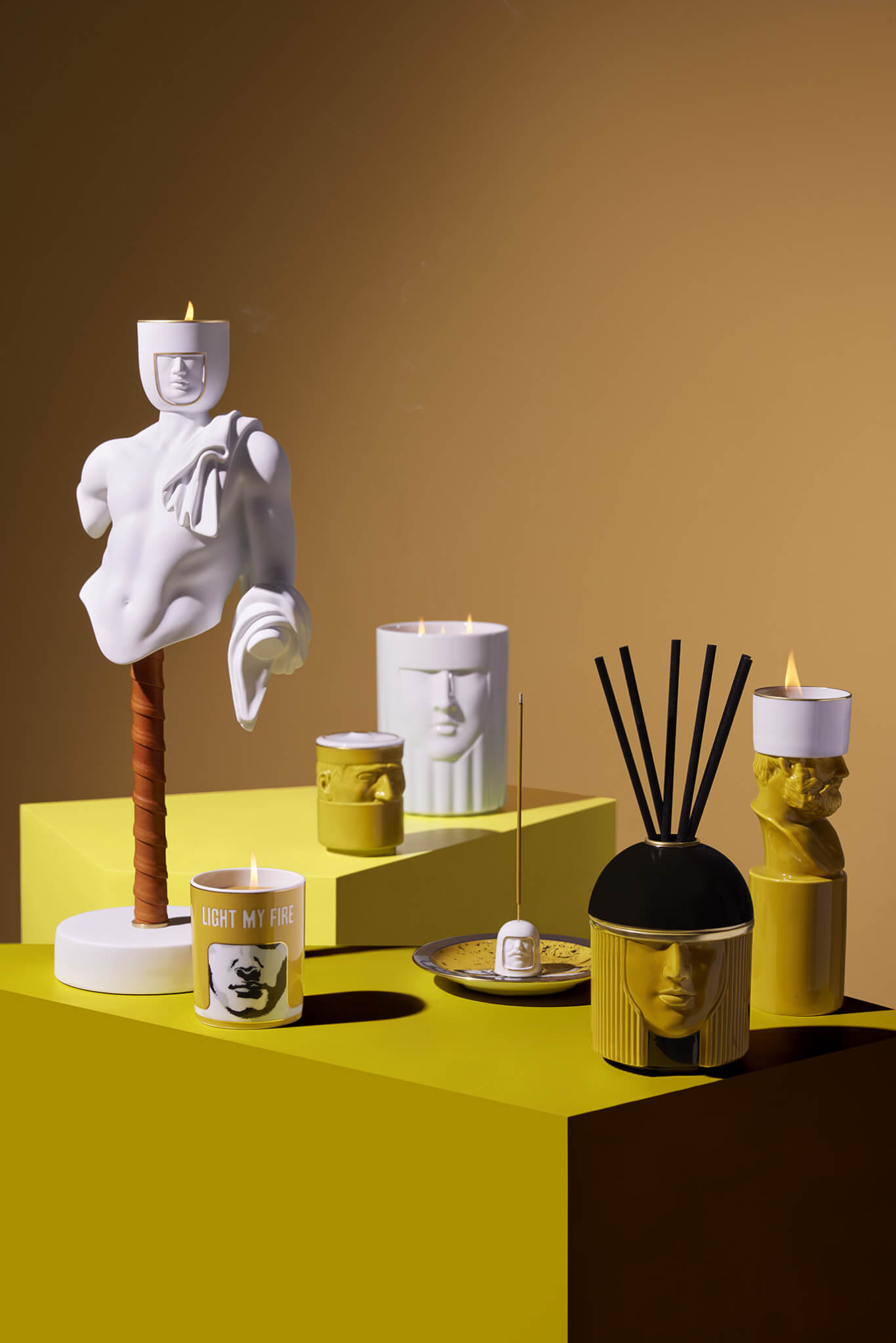 sculptures and incense holders on yellow table