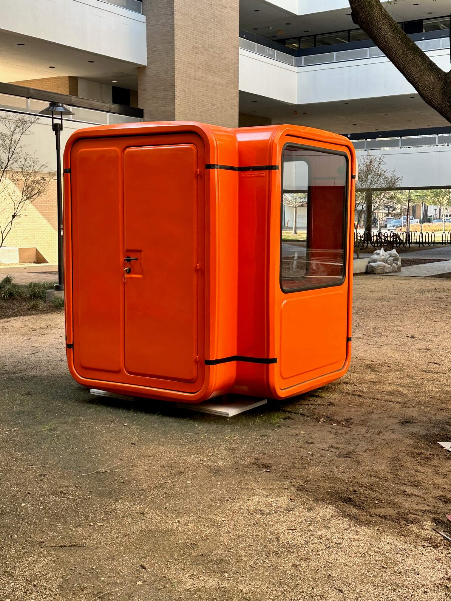 red kiosk sits in dirt lot