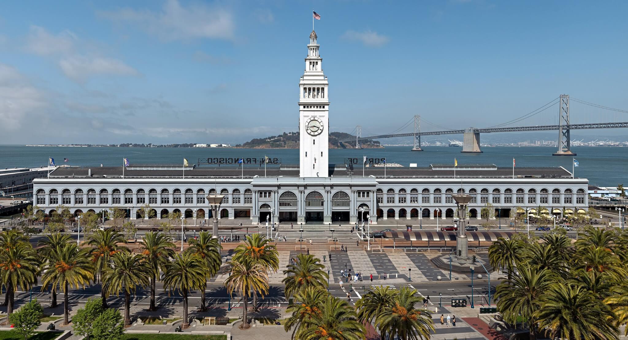 ferry building in san francisco with water and bridge