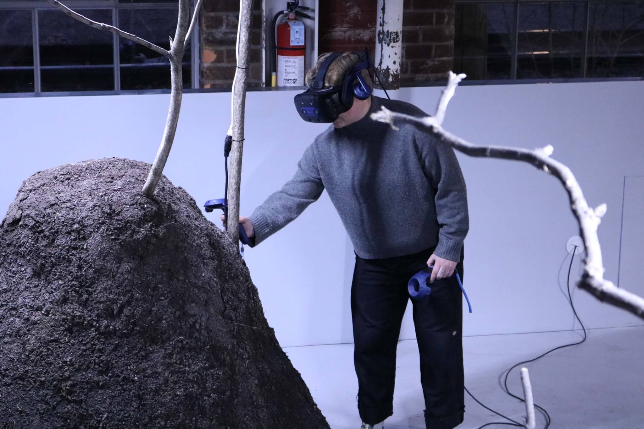 person with VR headset in front of idrt pile