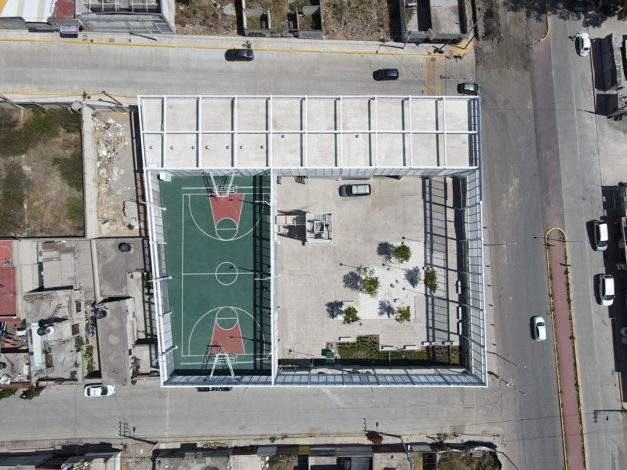Bird's eye view of fire station, featuring a basketball court and a recreational area inside the building/