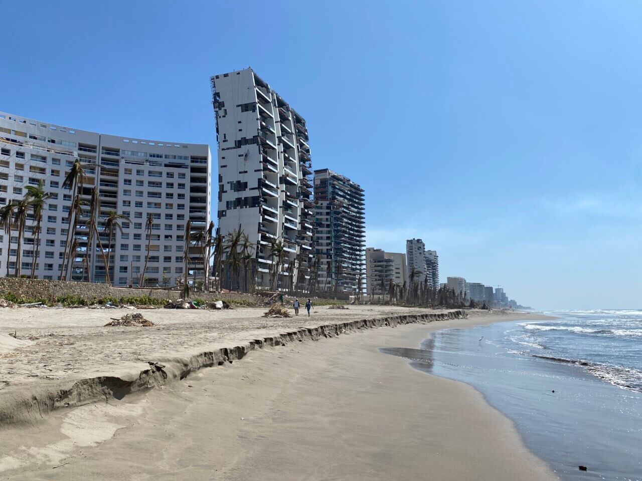 Image of beach shore with tall buildings damaged after a hurricane.