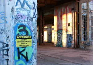graffiti wall with asbestos warning