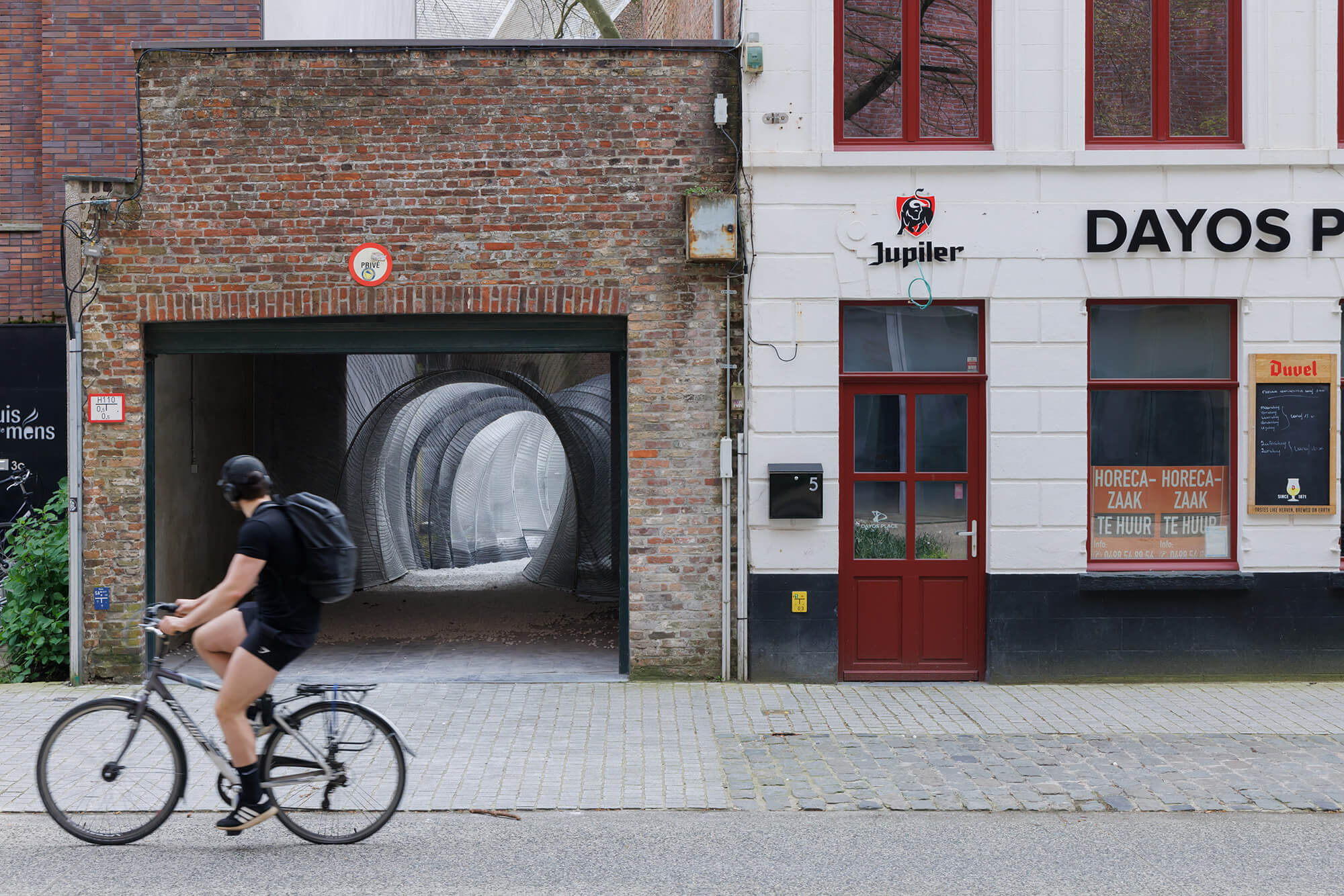 street with view looking into garage and installation for Bruges Triennial 