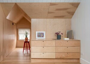 primary bedroom, wood clads the walls and ceiling, including the built-in dresser